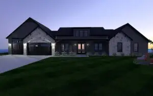 Elegant modern farmhouse glowing at twilight with stone accents and craftsman-style windows.