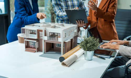 In an office room architect/engineer team discusses modern house - Custom Home Builder