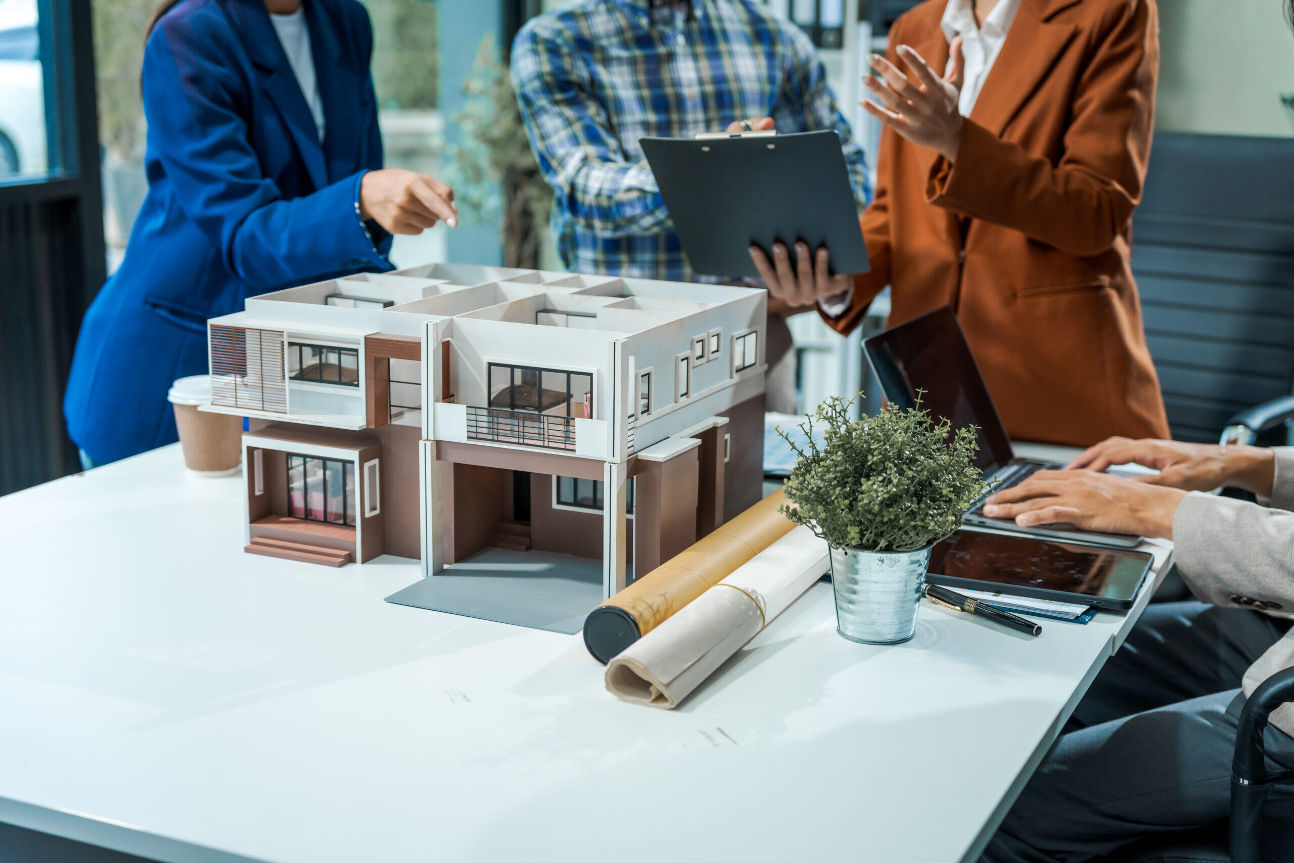 Innovative Home Building and Architectural Design in Boise - In an office room architect/engineer team discusses modern house - Custom Home Builder